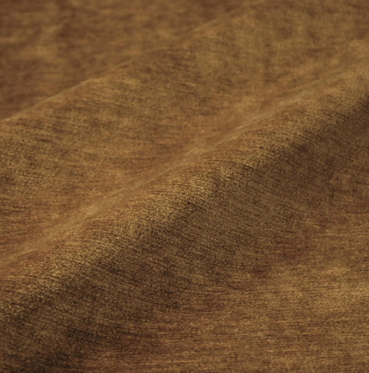 a close-up view of a textured fabric, possibly a brown or beige material, with a slightly curled and wrinkled appearance.