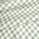 a close-up view of a fabric with a green and white checkered pattern, which appears to be a woven or knitted material.