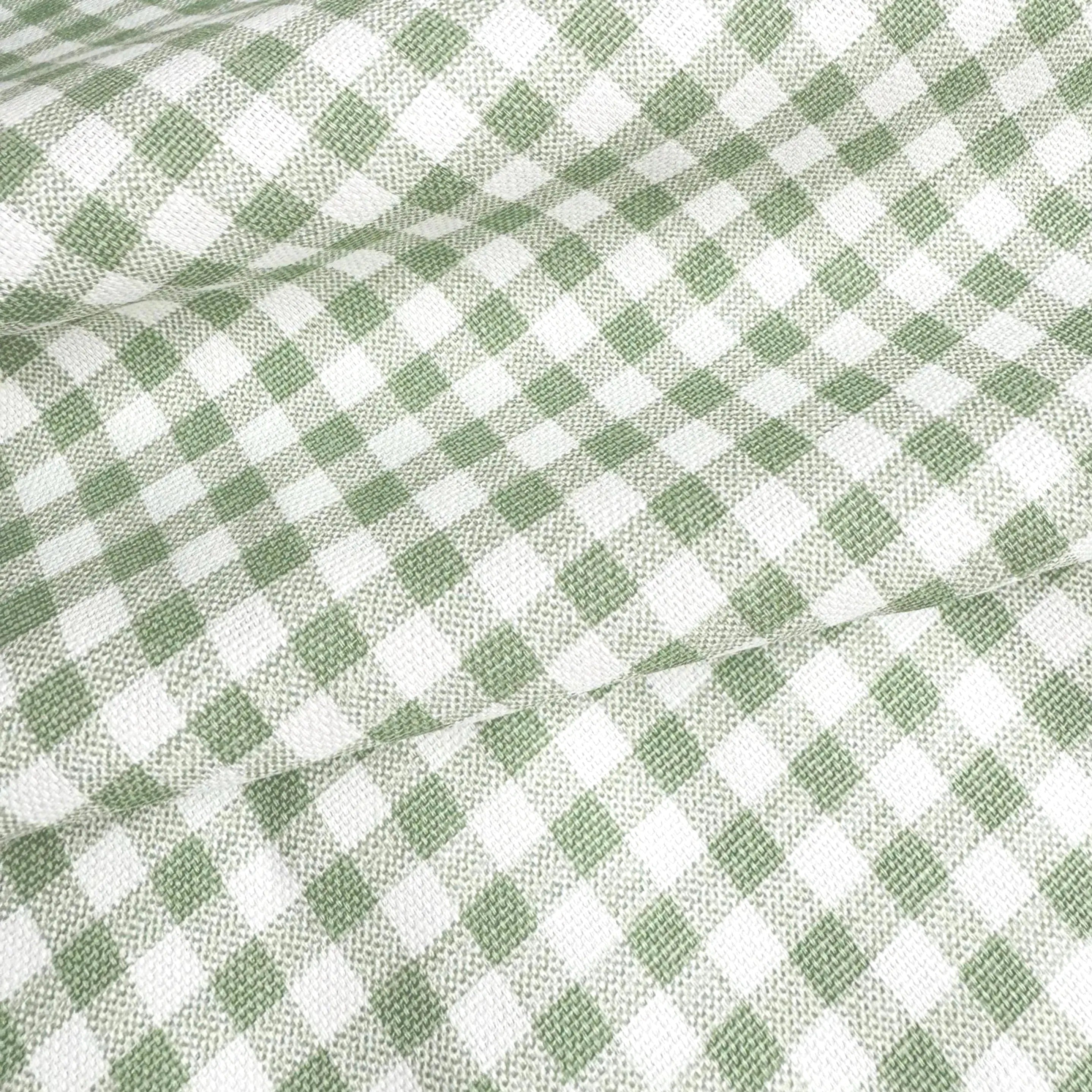 a close-up view of a fabric with a green and white checkered pattern, which appears to be a woven or knitted material.