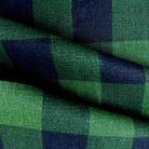 a close-up view of a fabric with a green and blue checkered pattern. The fabric appears to be made of a woven material, with a textured and wrinkled appearance.