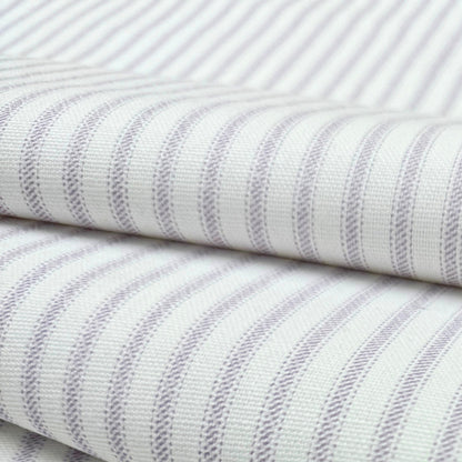 a close-up view of a fabric with a striped pattern in shades of white and purple. The fabric appears to be folded or rolled, with the edges of the fabric visible.