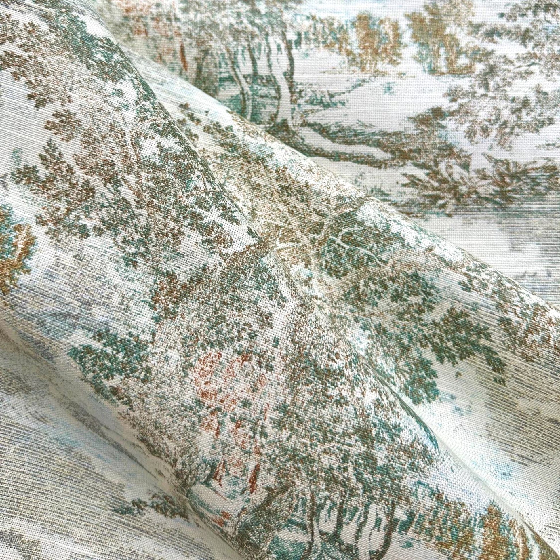 The image is a close-up of a fabric with a detailed pattern of trees and foliage, including a landscape scene.