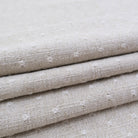 A close-up view of a folded fabric with a textured, beige-colored appearance.