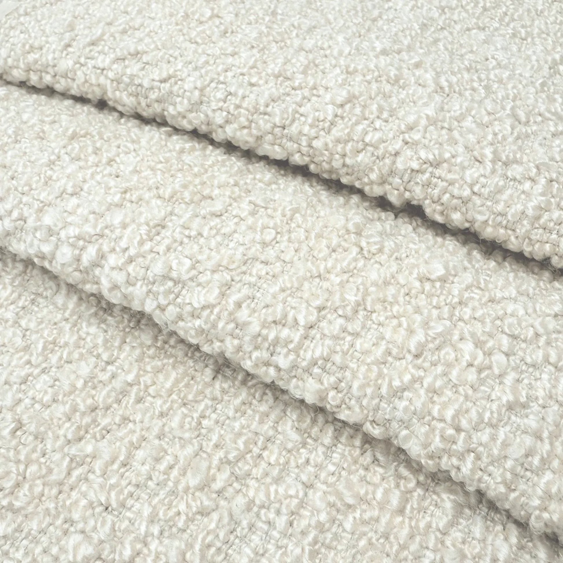 A close-up image of a soft, fluffy, and textured fabric, possibly a type of wool or a similar material.