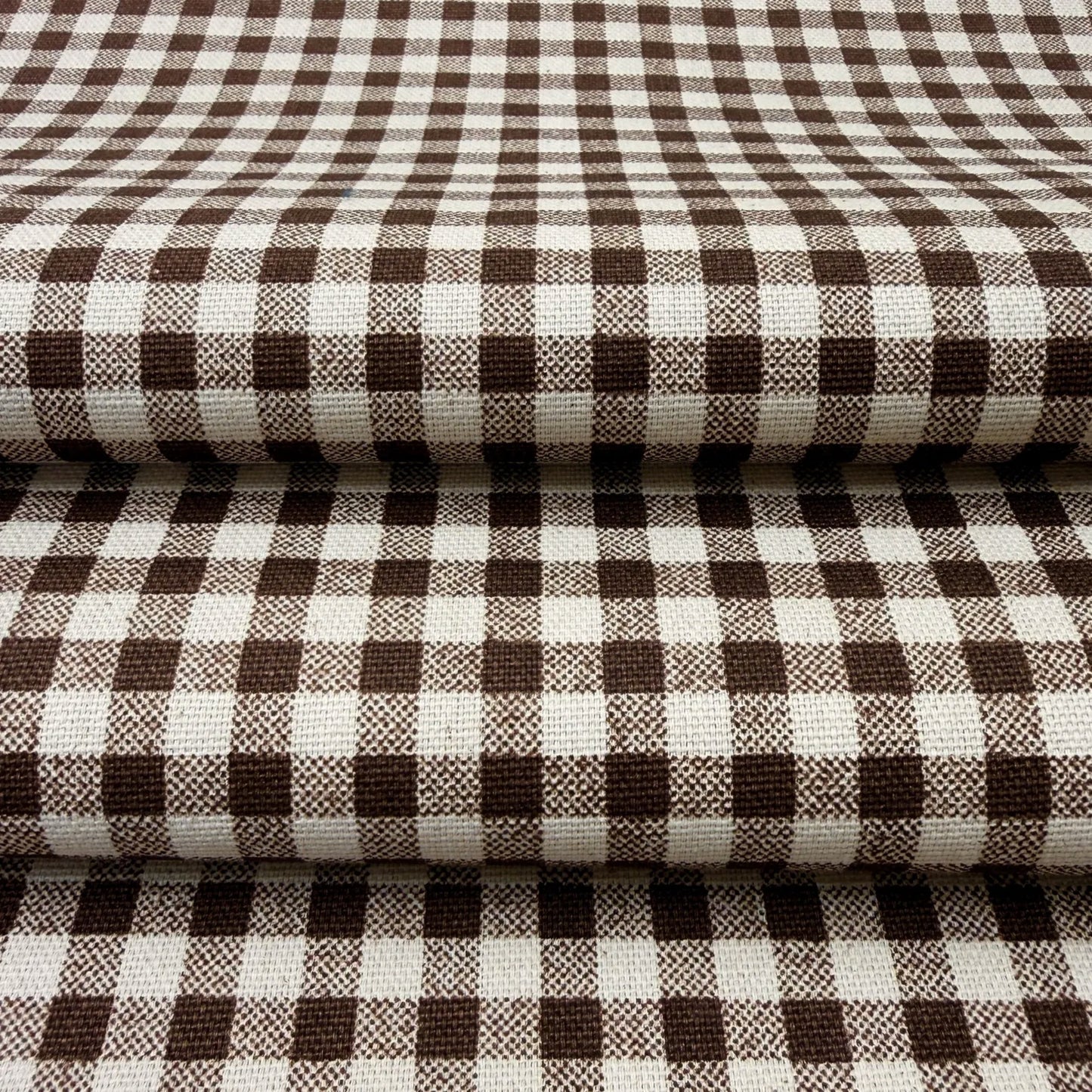 a close-up view of a fabric with a checkered pattern in shades of brown and white.