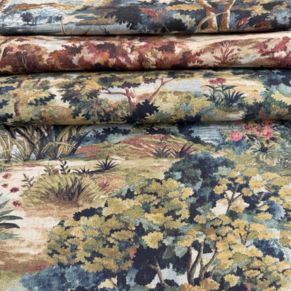 a close-up view of a fabric with a detailed landscape pattern, including trees, bushes, and flowers in various shades of green, brown, and red.