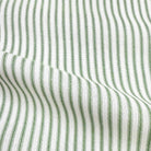 a close-up view of a fabric with a striped pattern in shades of green and white. The fabric appears to be made of a woven material, with the green stripes standing out against the white background.
