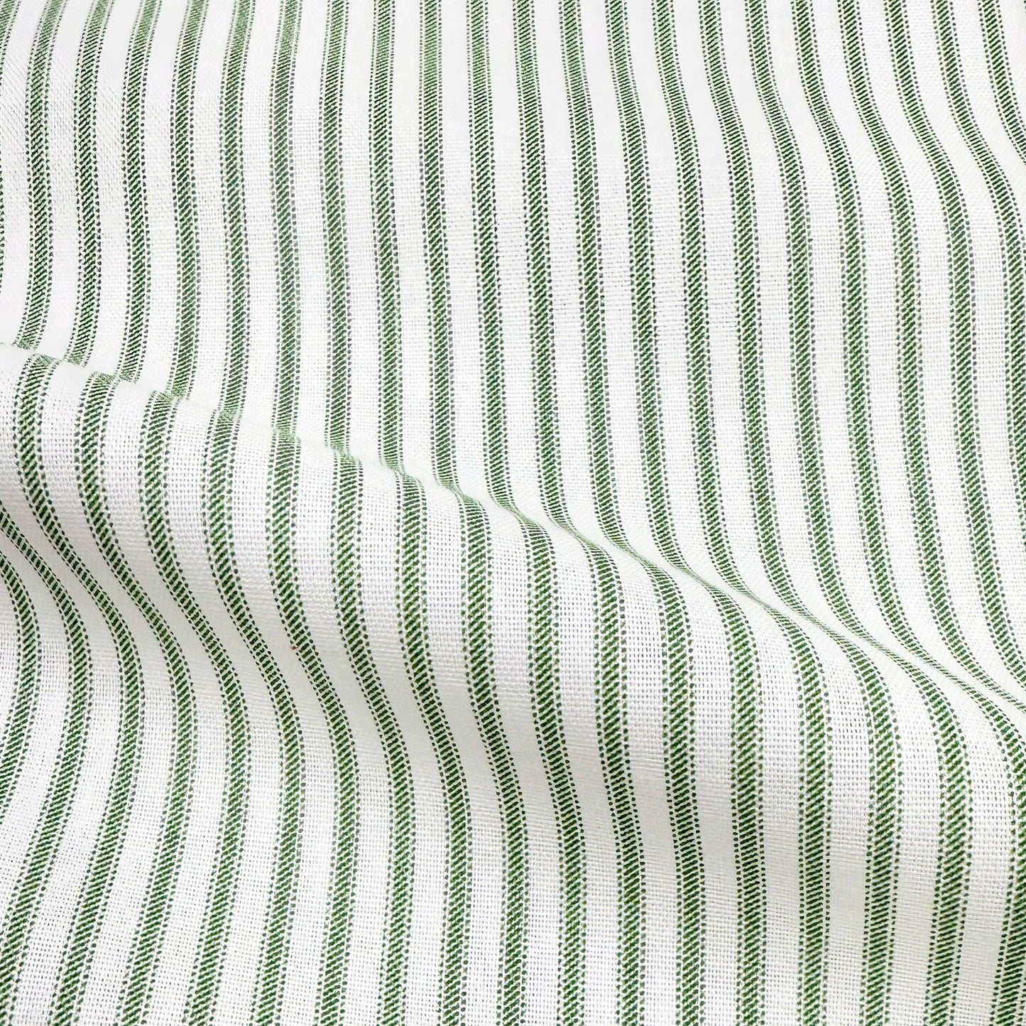 a close-up view of a fabric with a striped pattern in shades of green and white. The fabric appears to be made of a woven material, with the green stripes standing out against the white background.