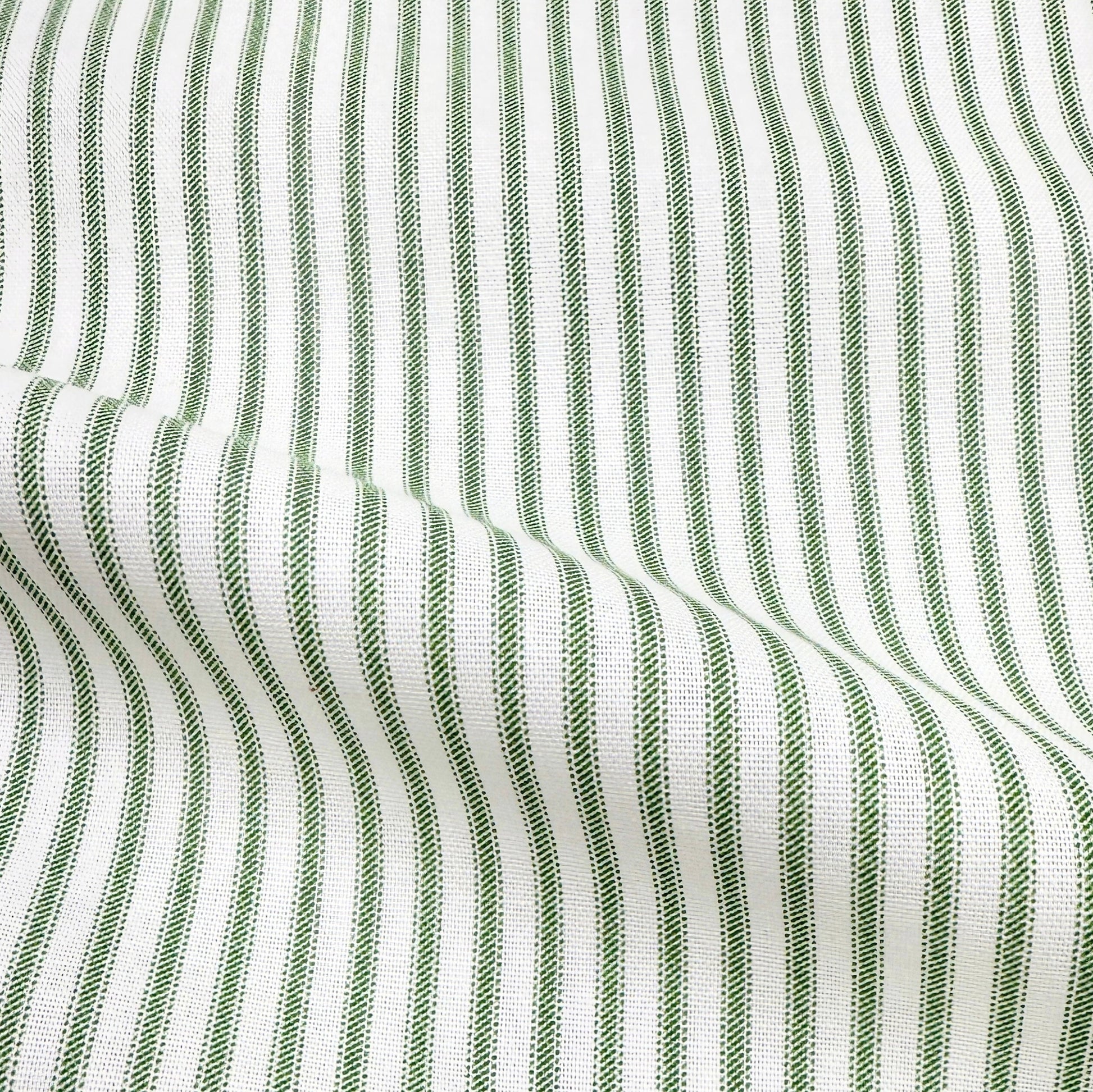a close-up view of a fabric with a striped pattern in shades of green and white. The fabric appears to be made of a woven material, with the green stripes standing out against the white background.