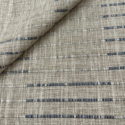 a close-up view of a textured fabric with a striped pattern in shades of gray and blue.