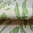 a close-up view of a fabric with a repeating pattern of green leaves and ferns. The fabric appears to be woven or knitted, with a textured surface that gives it a natural, organic appearance. The pattern is intricate and detailed, with the leaves and ferns filling the entire visible area of the fabric.