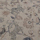 Beige fabric with a repeating pattern of stylized animals and floral elements. The design features tigers, deer, and birds interspersed with large, ornate flowers and foliage in shades of brown and gray. The fabric has a textured appearance.