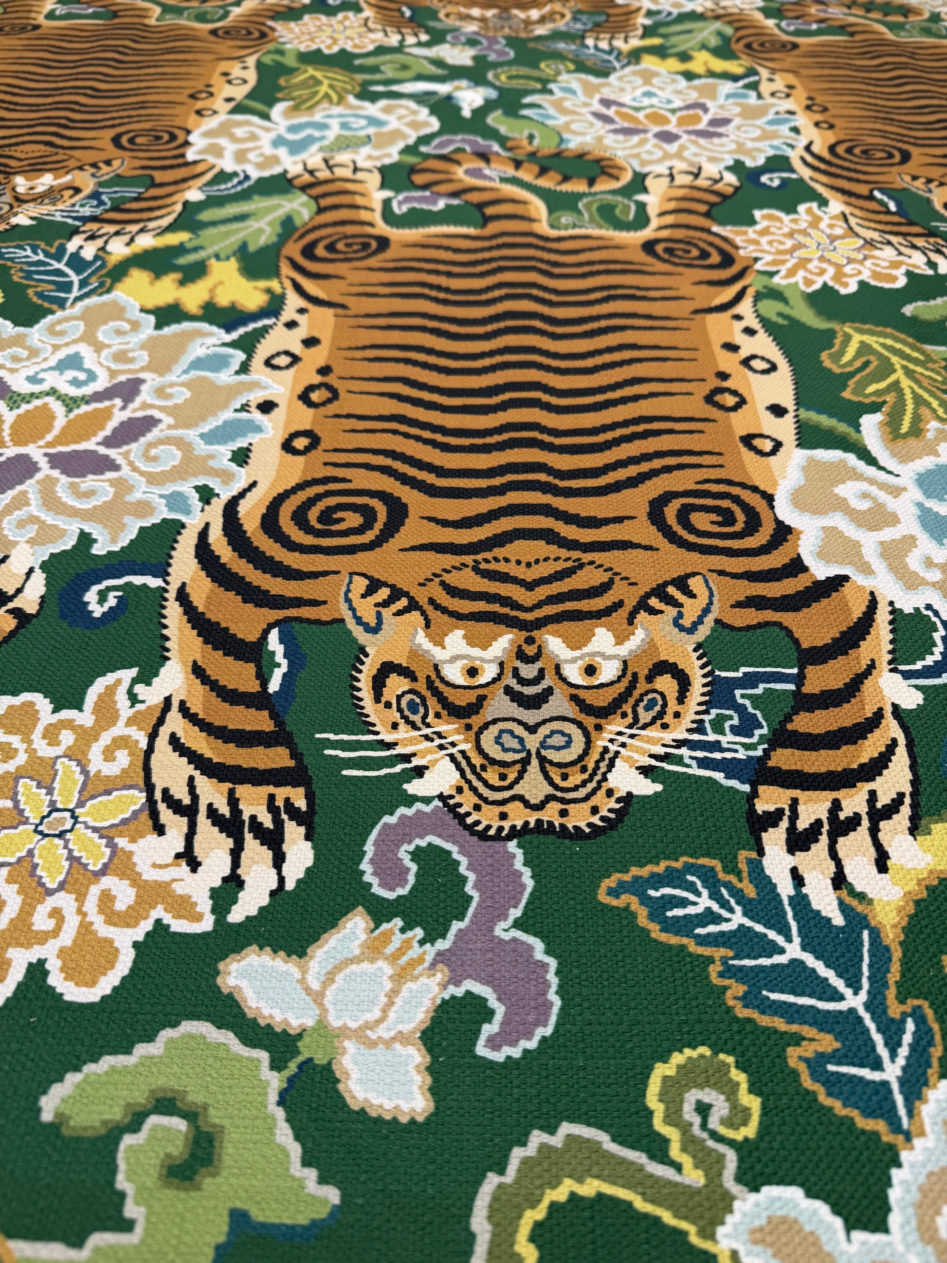 Close-up of the intricate gold tiger and botanical floral motif on a rich emerald green background.