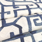 a close-up view of a fabric with a repeating pattern of blue and white geometric shapes, creating a visually striking and intricate design.