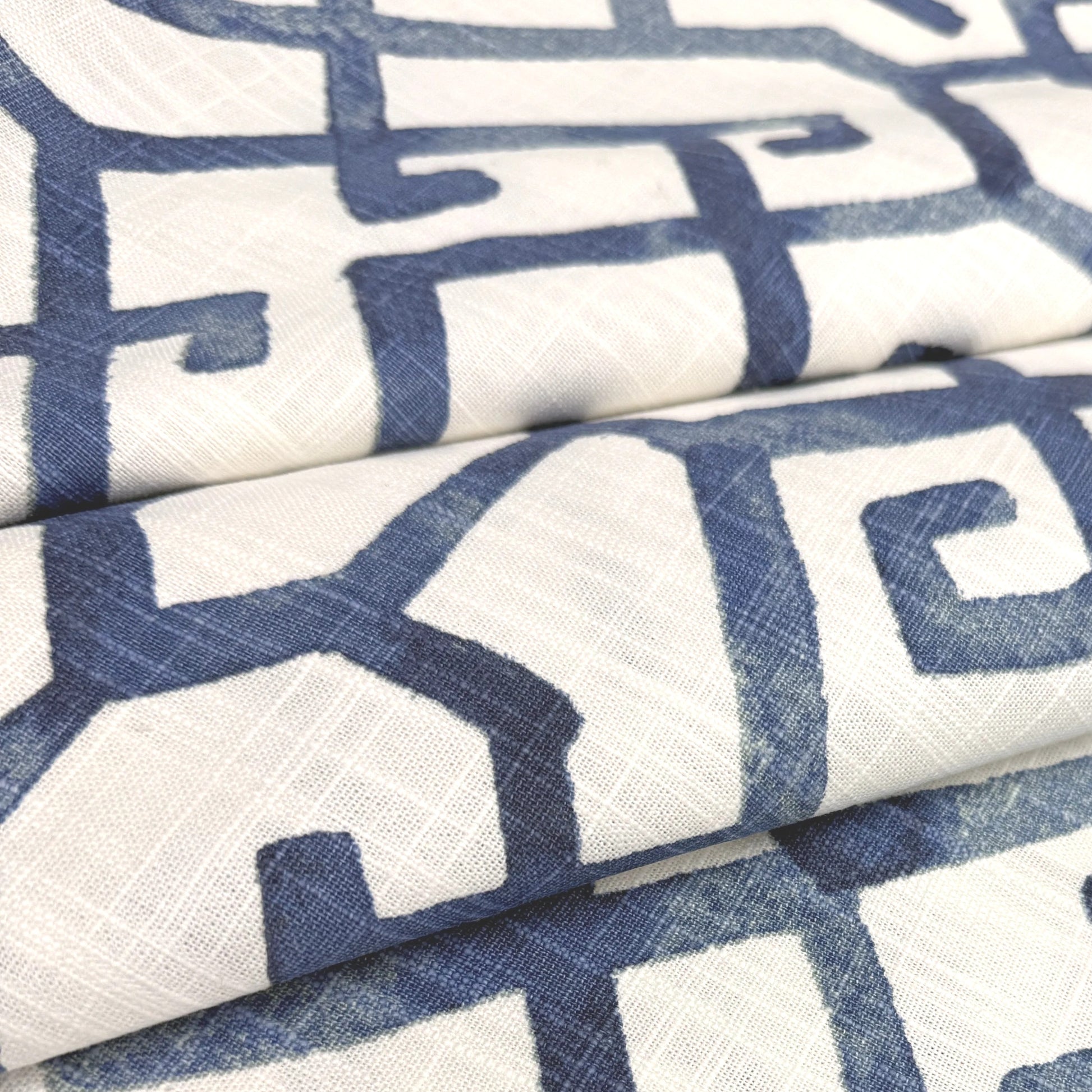 a close-up view of a fabric with a repeating pattern of blue and white geometric shapes, creating a visually striking and intricate design.