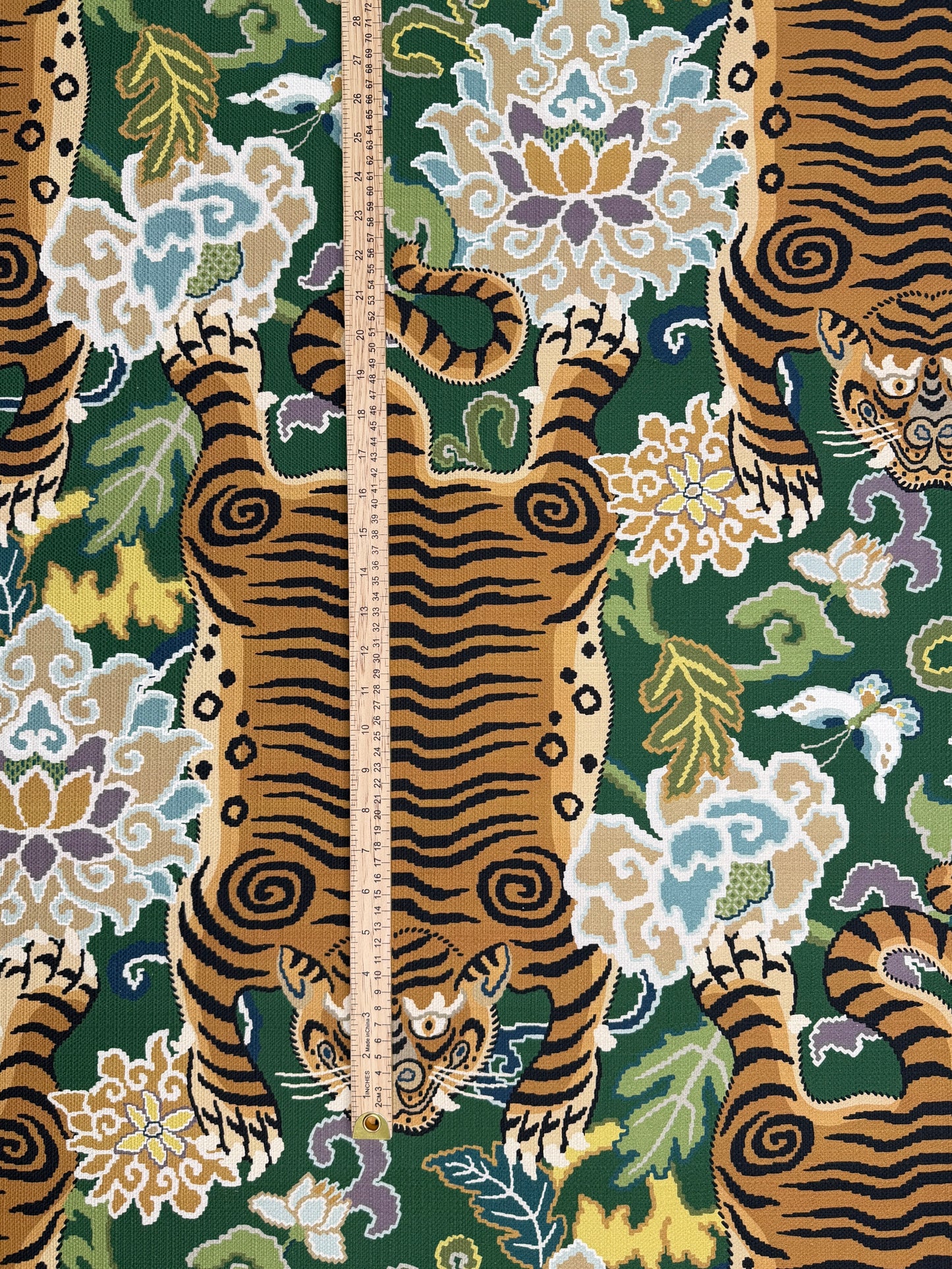 Scale reference with a ruler measuring the height and repeat of the tiger pattern on the emerald green upholstery fabric.