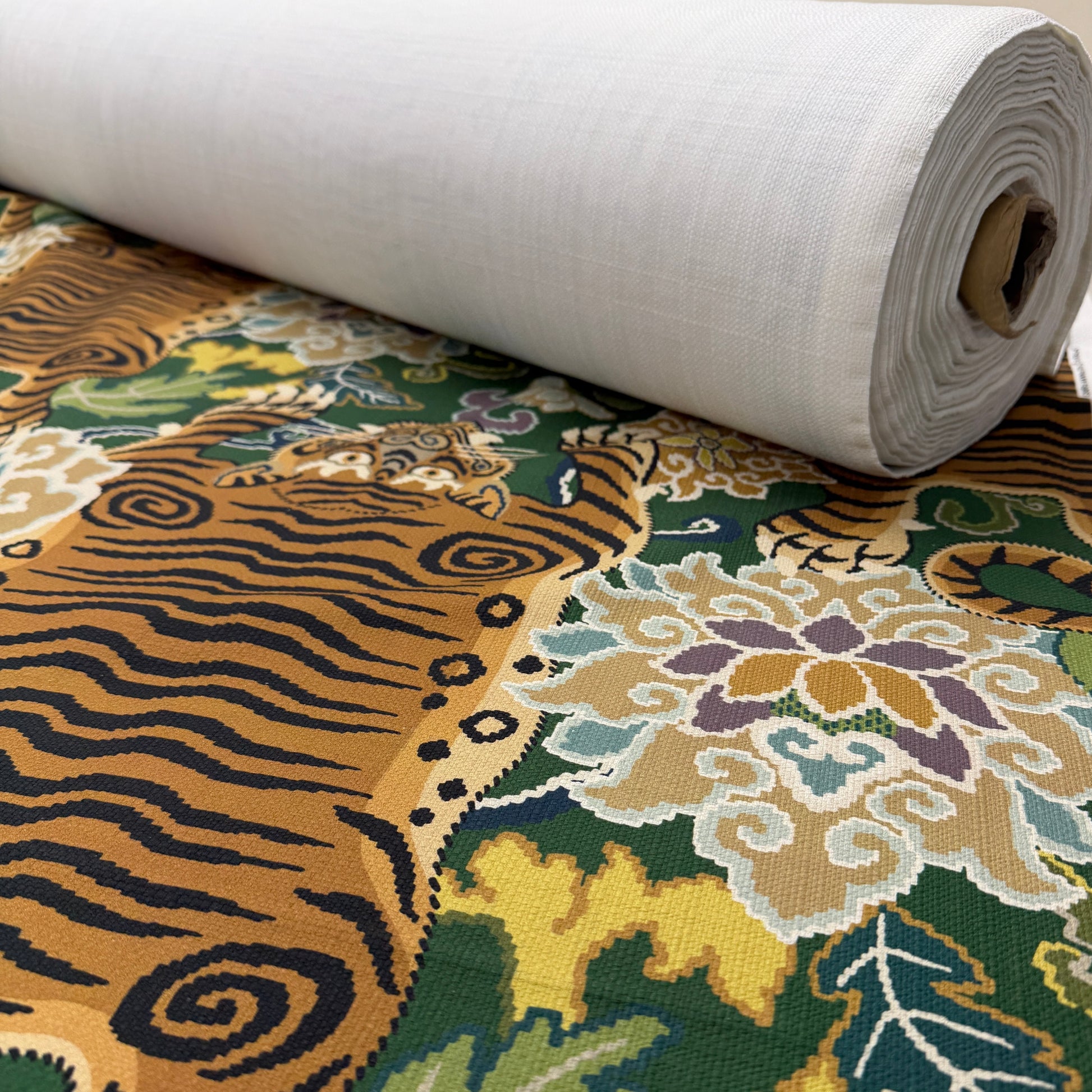 Emerald green tiger fabric on a bolt, illustrating how the textile is cut to order by the yard.