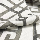 a close-up view of a fabric with a geometric pattern in shades of gray and white.