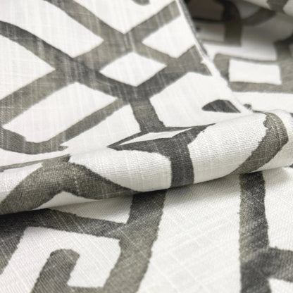 a close-up view of a fabric with a geometric pattern in shades of gray and white.