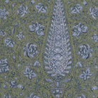 a detailed and intricate paisley pattern with a large central motif surrounded by smaller floral and leaf-like designs in shades of green and blue. The pattern appears to be a textile or wallpaper design, with the central motif being the focal point.