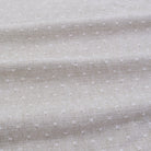 a close-up view of a fabric with small white dots or polka dots, creating a textured and patterned appearance.