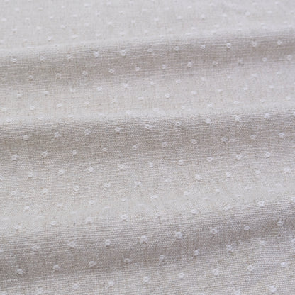 a close-up view of a fabric with small white dots or polka dots, creating a textured and patterned appearance.