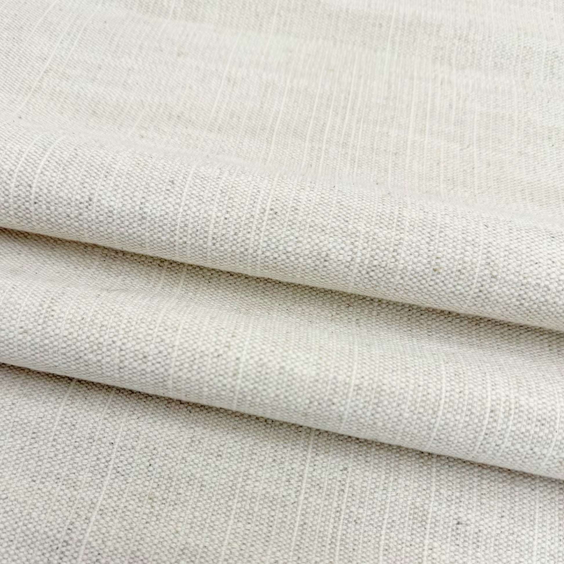 Soft drapes of natural cream slub linen fabric perfect for custom curtains and home decor.