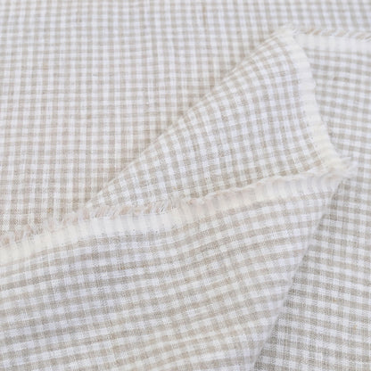 Textured gingham check fabric in beige and white, ideal for cushions and table linens