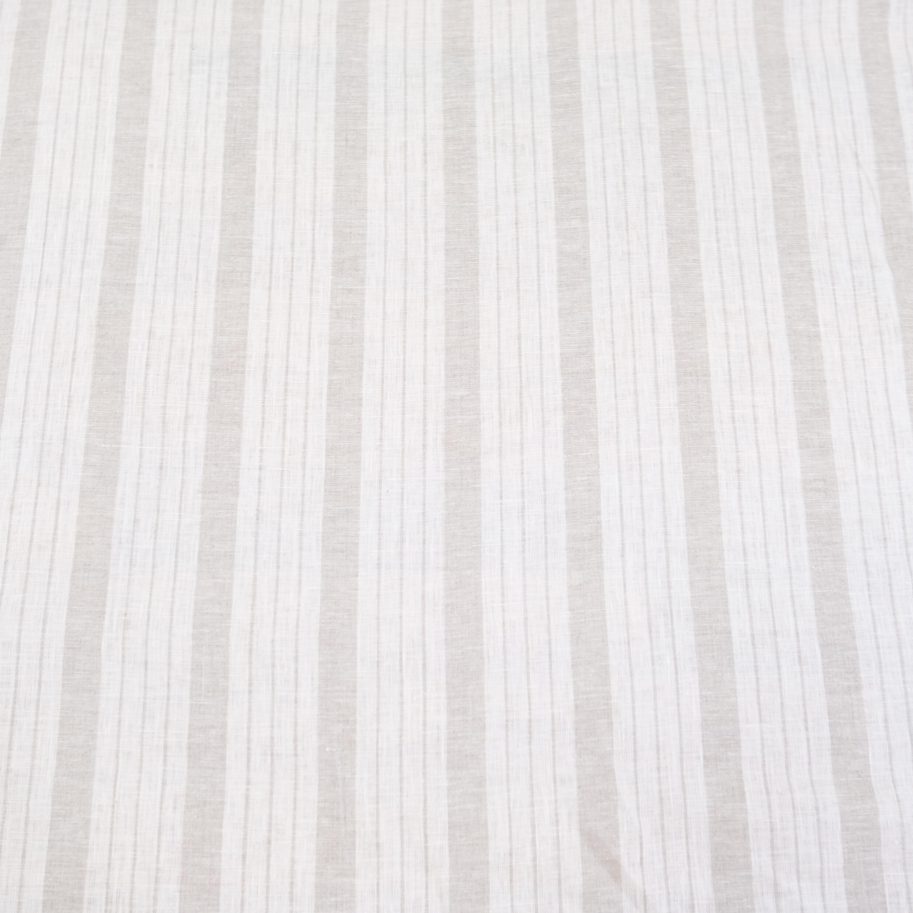 Flat lay of taupe striped linen fabric showing even balanced stripes and neutral color tones. The fabric’s light drape makes it perfect for farmhouse style drapery, rustic table runners, DIY napkins, and cottage-style crafts. This striped linen is a versatile choice for sewing enthusiasts looking to create timeless, minimalist home décor items with natural linen texture and neutral earthy stripes.