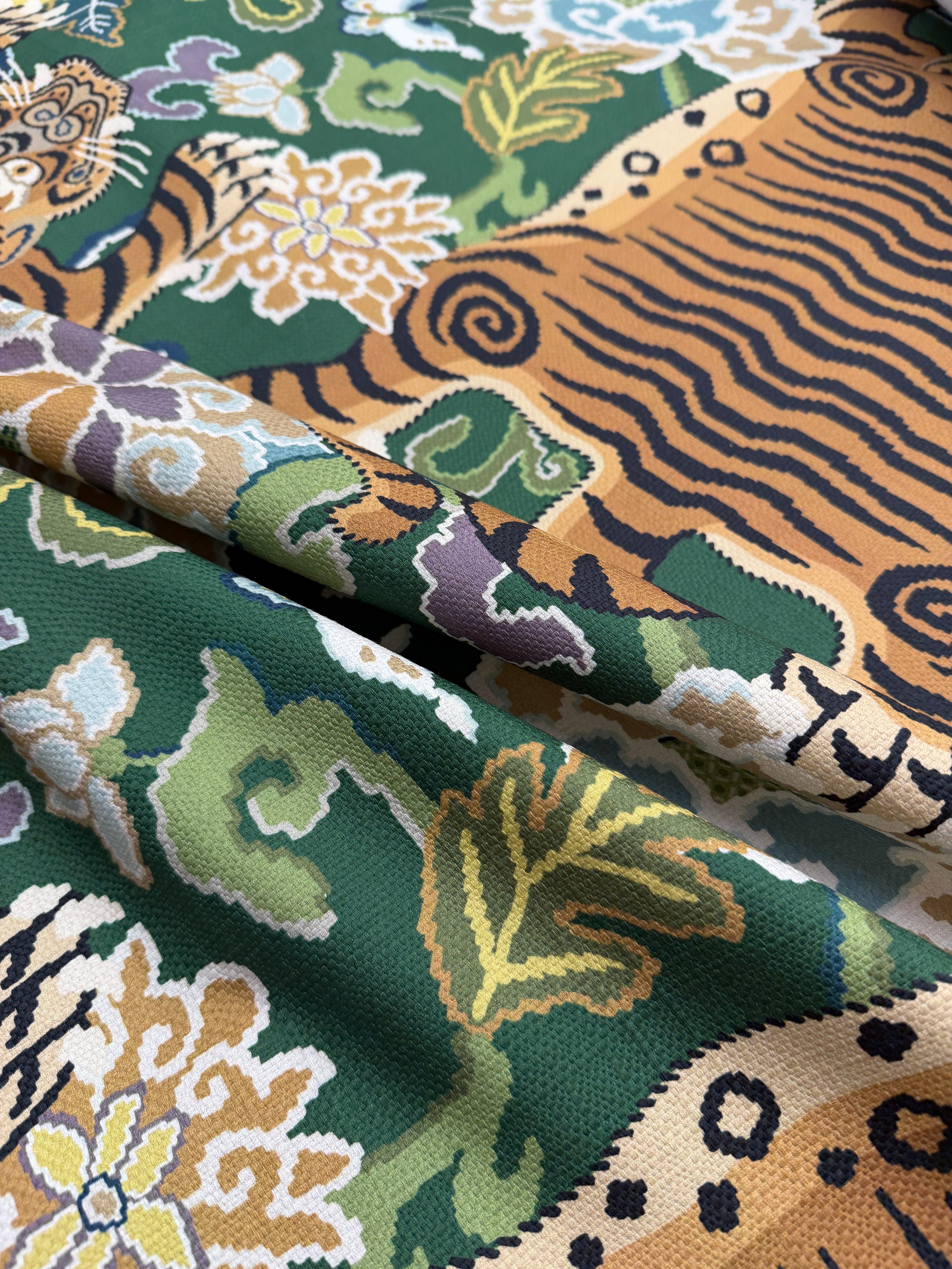 Close-up of draped 100% cotton emerald green tiger fabric showing the textile's soft texture and rich jewel-tone color.