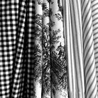 A close-up view of several fabric swatches, including a black and white checkered fabric, a fabric with a black and white floral pattern, and a fabric with a striped pattern.