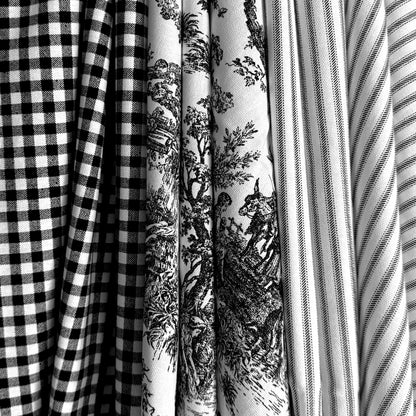 A close-up view of several fabric swatches, including a black and white checkered fabric, a fabric with a black and white floral pattern, and a fabric with a striped pattern.