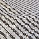 A close-up view of a fabric with diagonal black and white stripes.