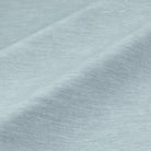 a close-up view of a textured fabric, possibly a piece of clothing or a textile. The fabric appears to be a light blue color, with a slightly wrinkled and folded appearance. The image does not contain any discernible objects or actions, and there are no specific actions or objects that can be described in detail.