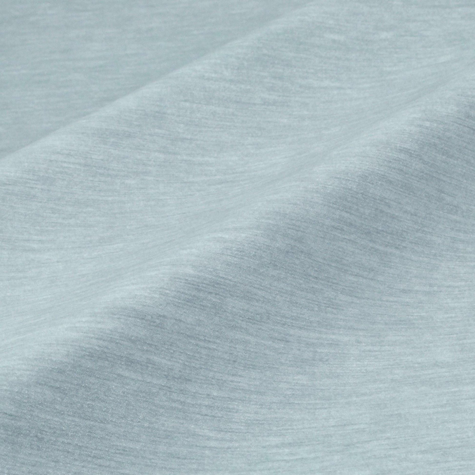 a close-up view of a textured fabric, possibly a piece of clothing or a textile. The fabric appears to be a light blue color, with a slightly wrinkled and folded appearance. The image does not contain any discernible objects or actions, and there are no specific actions or objects that can be described in detail.
