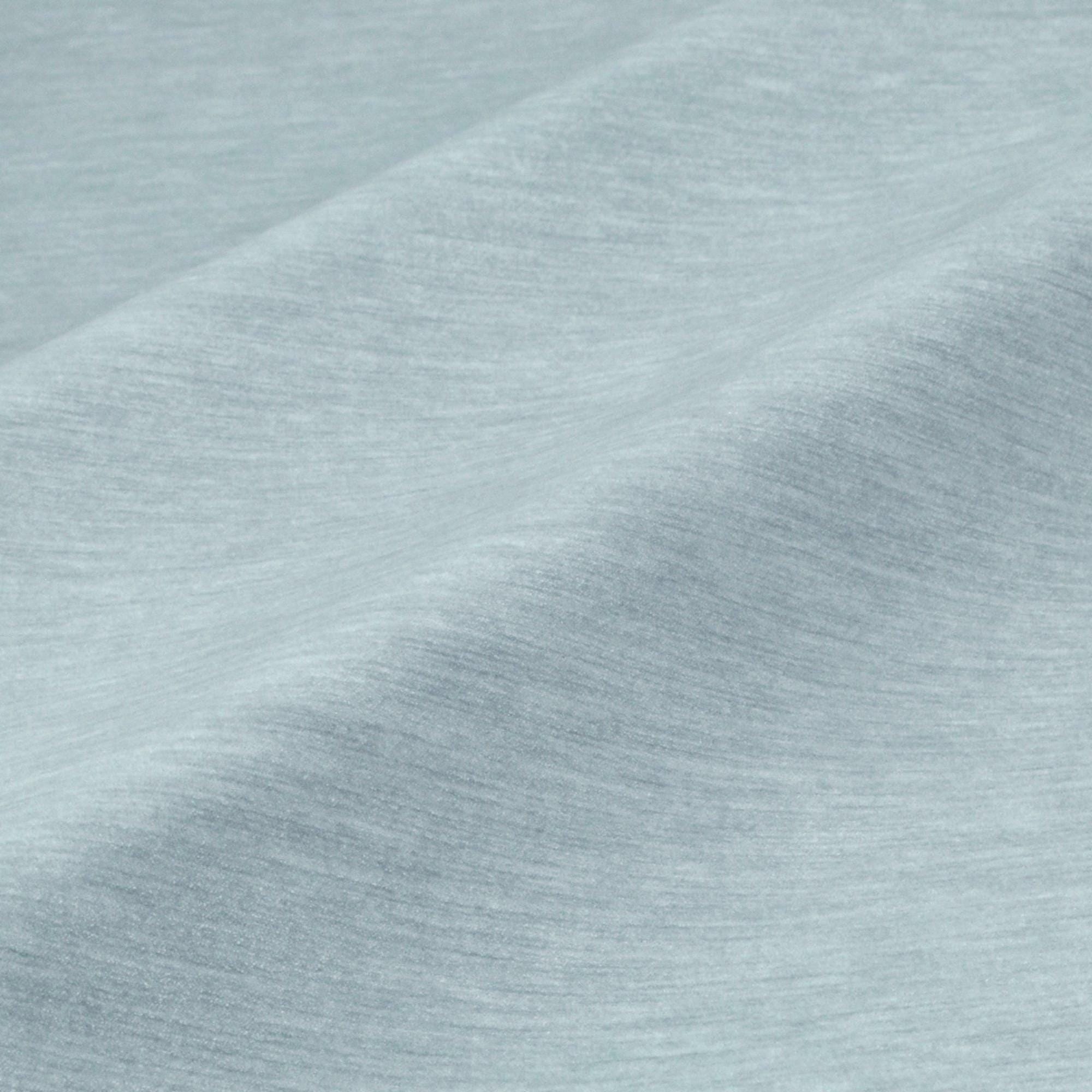 a close-up view of a textured fabric, possibly a piece of clothing or a textile. The fabric appears to be a light blue color, with a slightly wrinkled and folded appearance. The image does not contain any discernible objects or actions, and there are no specific actions or objects that can be described in detail.