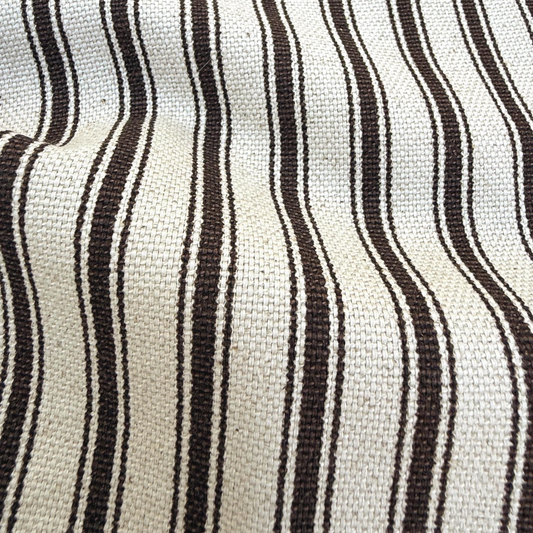a close-up view of a fabric with a striped pattern in shades of white and brown.