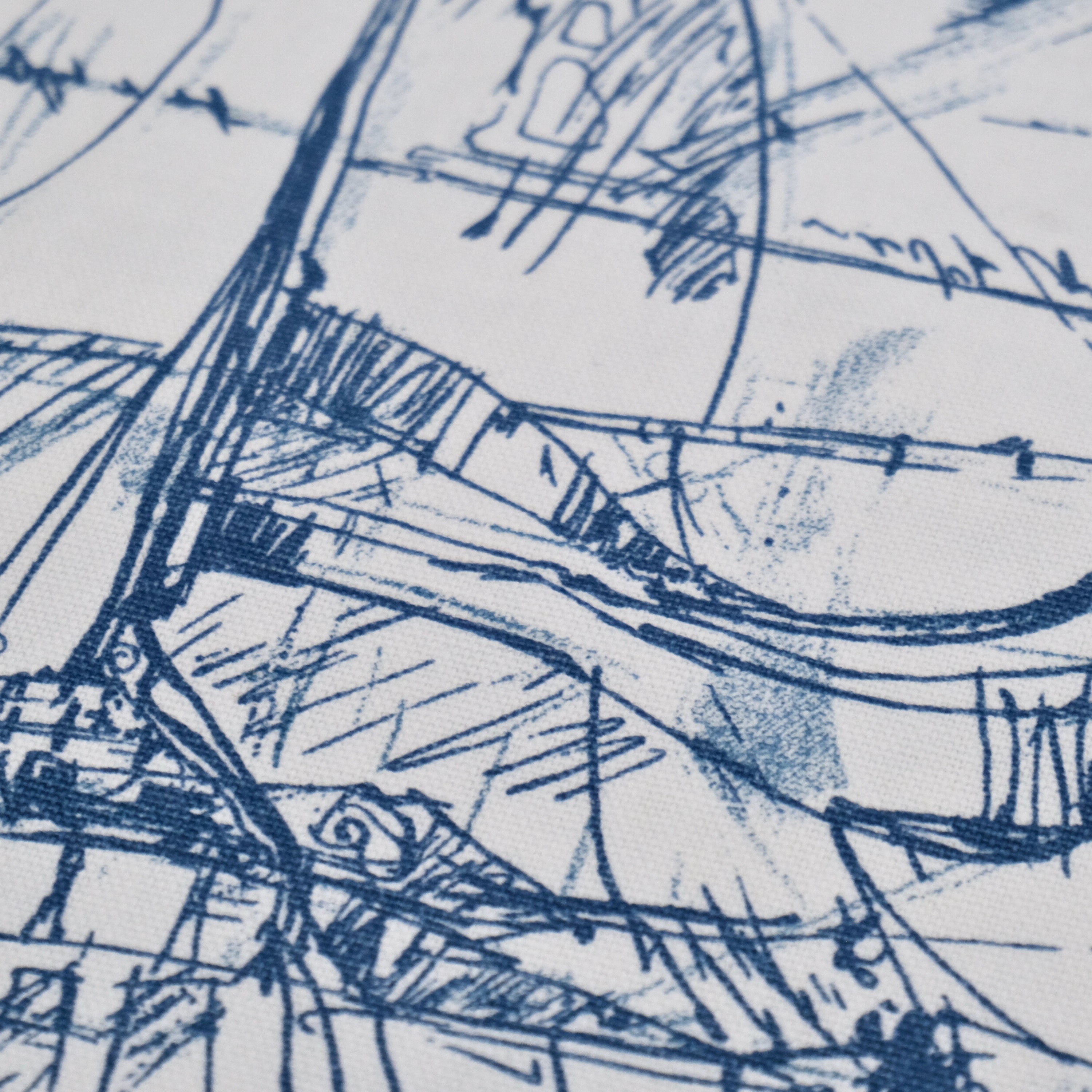 The image is a close-up of a textured fabric with a blue and white abstract pattern. The pattern consists of various lines, curves, and shapes, creating a visually interesting and dynamic design.