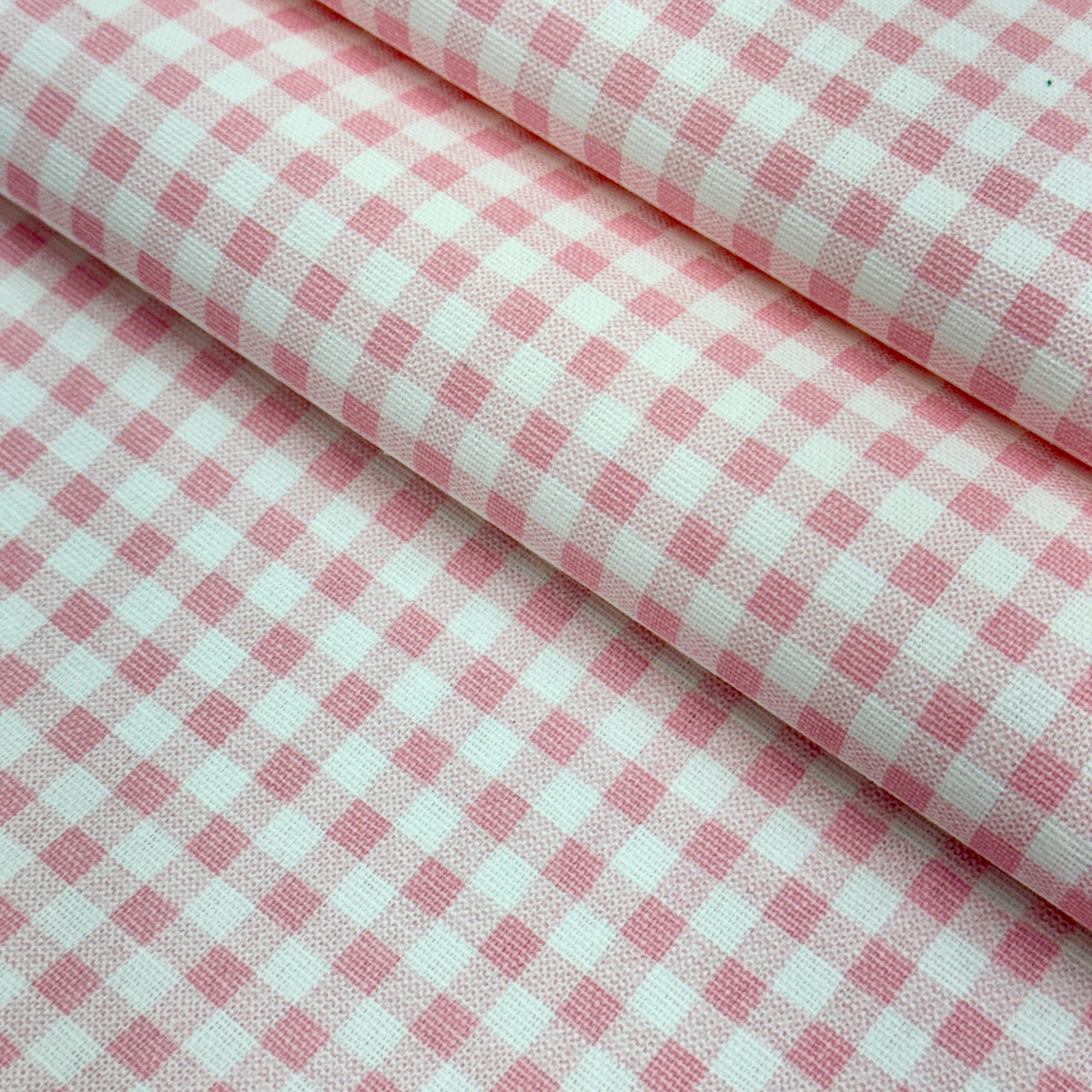 a close-up view of a fabric with a pink and white checkered pattern.