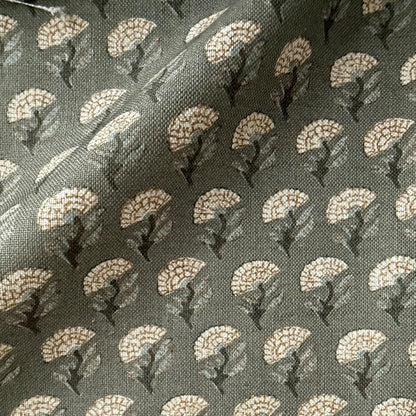 a close-up view of a fabric with a repeating pattern of white flowers or leaves on a dark background.