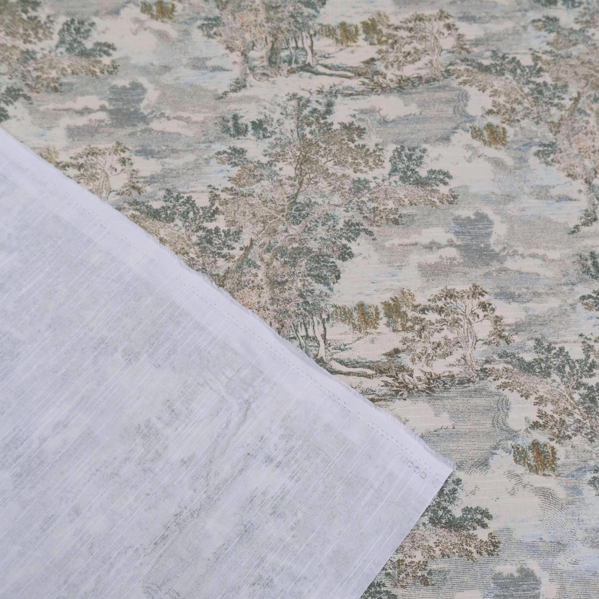 a close-up view of a fabric with a pattern of trees and foliage, including a landscape scene. The fabric appears to be a piece of cloth or textile, with a white or light-colored background. The pattern on the fabric is intricate and detailed, showcasing the craftsmanship and design elements.
