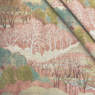 The Pink Scenic Forest Landscape Fabric folded diagonally, demonstrating its textile weight, woven texture, and suitability for upholstery and drapery.
