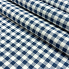 a close-up view of a fabric with a blue and white checkered pattern. The fabric appears to be folded or rolled up, creating a visually appealing and textured design.