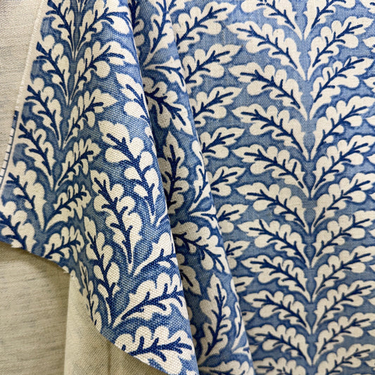 Blue floral vine fabric in soft folds showing repeating botanical pattern design
