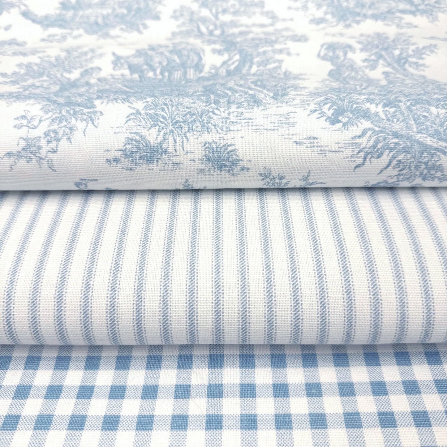 a close-up view of a stack of fabric swatches, showcasing a variety of patterns and textures.