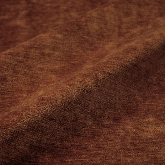 a close-up view of a brown fabric, possibly a piece of clothing or a textile. The fabric has a textured and wrinkled appearance, suggesting it might be made of a natural or organic material.