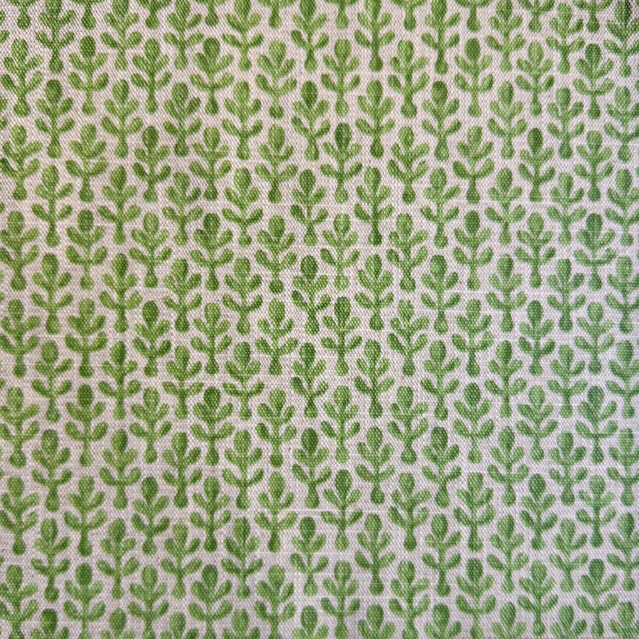 a repeating pattern of green leaves on a fabric surface.