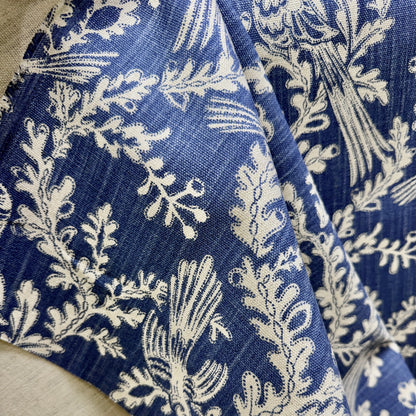 Close-up of blue floral fabric with cream botanical pattern and detailed vine design