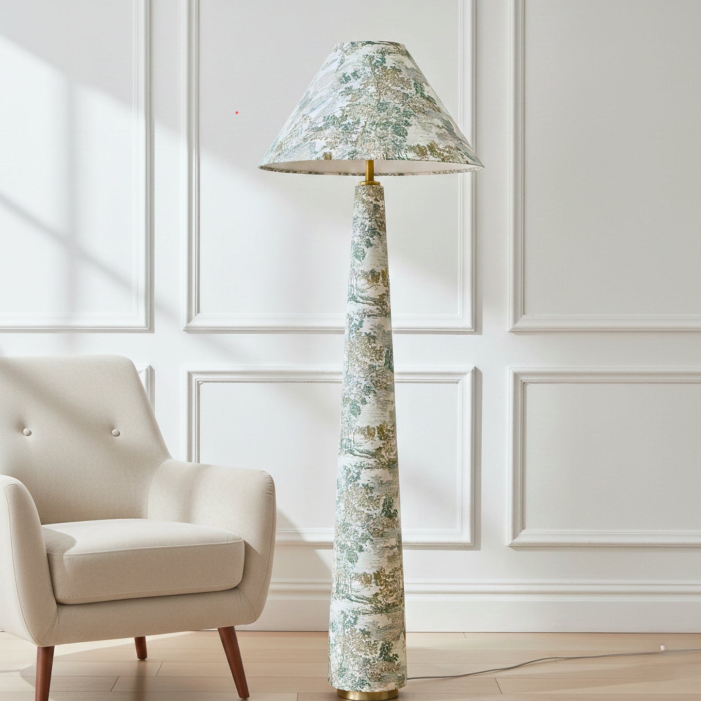 a tall floor lamp with a green and white floral patterned lampshade, standing next to a beige armchair in a room with white paneled walls.