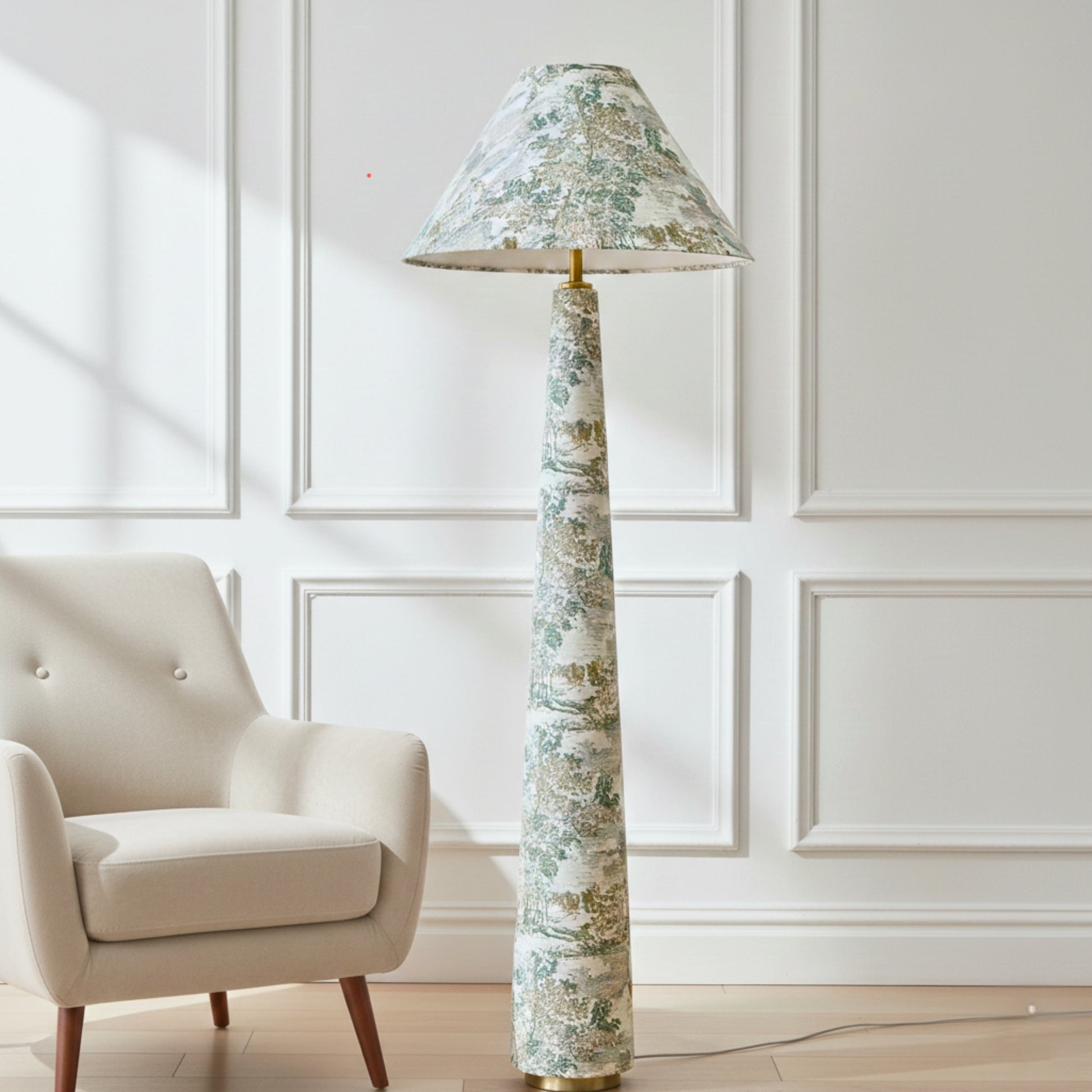 a tall floor lamp with a green and white floral patterned lampshade, standing next to a beige armchair in a room with white paneled walls.